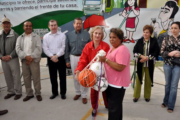 Durante la ceremonia protocolaria, la Presidenta del DIF, señora Alma Catalina Erhard de Vela, acompañada por el Primer Regidor, hizo entrega de material deportivo a las representantes de la colonia, a fin de promover actividades positivas entre los niños y jóvenes del sector.